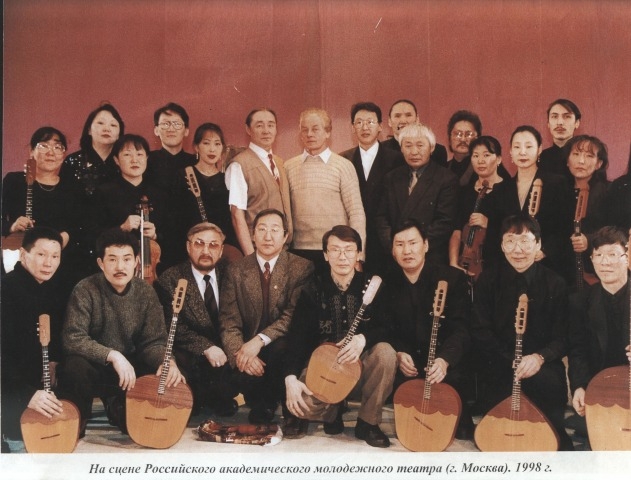 Обложка Электронного документа: Артисты оркестра и деятели искусства на сцене Российского академического молодежного театра: [фотография]