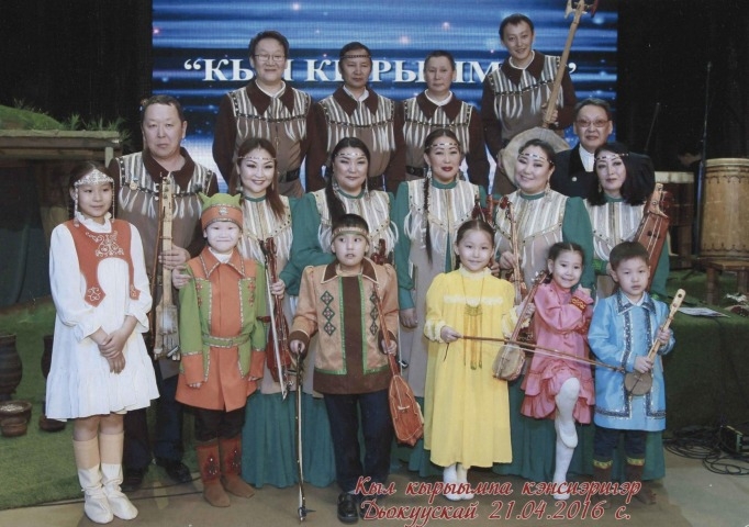 Обложка Электронного документа: Музыканты ансамбля "Кыл Саха" с детьми после первого концерта ансамбля "Кыл кырыымпа" в Доме дружбы народов им. А. Е. Кулаковского: [фотография]